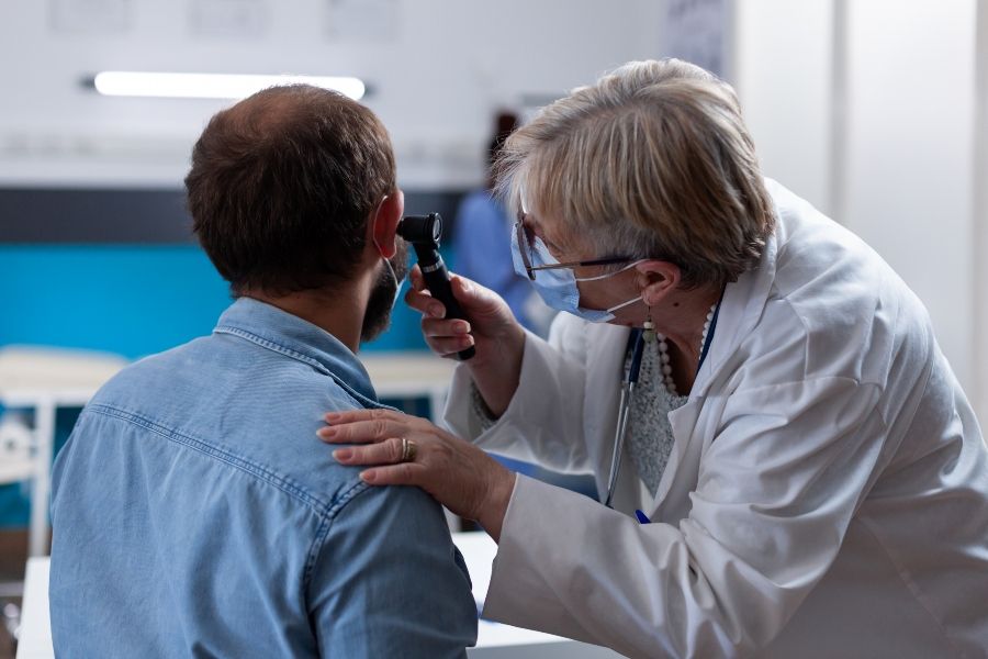 close-up-physician-using-otoscope-ear-consultation-with-patient-woman-otologist-checking-900x600.jpg