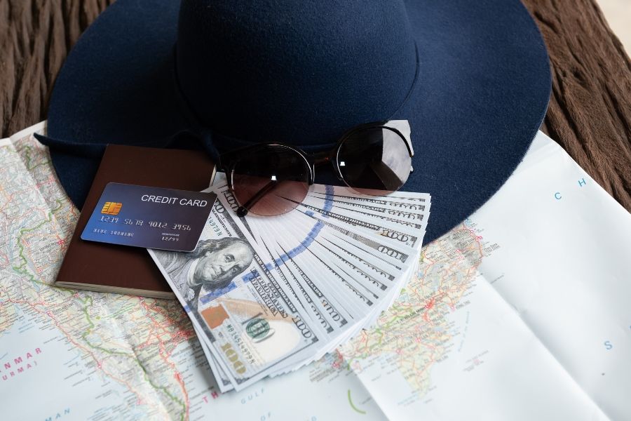 dollar-banknotes-sunglasses-credit-card-passport-blue-hat - 900x600.jpg